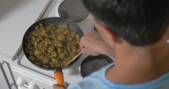 Man cooking stewed vegetables at home alt