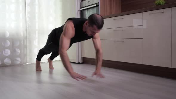 A Man Performs Push-ups From the Floor at Home.