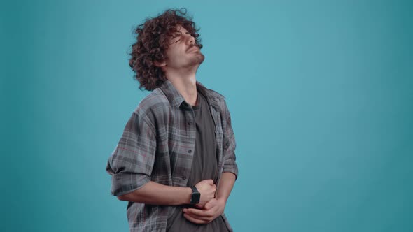 The Grieving Young Man Clings to His Stomach Feels an Acute Pain That Makes Him Close His Eyes and alt