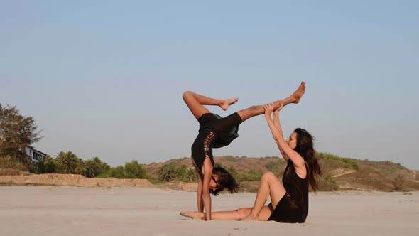 Mom Trains a Teen Daughter to Perform Acrobatic Element on the Beach