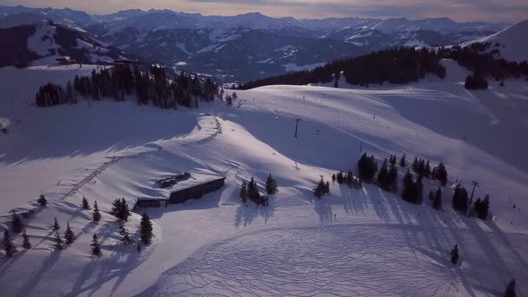 Snowy mountains in low clouds and blue sky at sunset in winter. Panoramic landscape with beautiful s alt