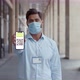 Portrait of Office Worker in Safety Mask Showing Smartphone Screen with Vaccinated Qrcode at Camera