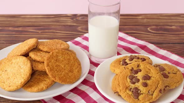 Pile of Chocolate Chip Cookies on White Plate and Milk Glass on Wooden Table
