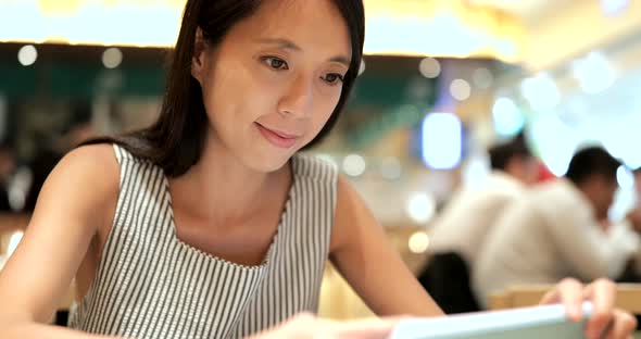 Young Woman making order on tablet inside restaurant alt