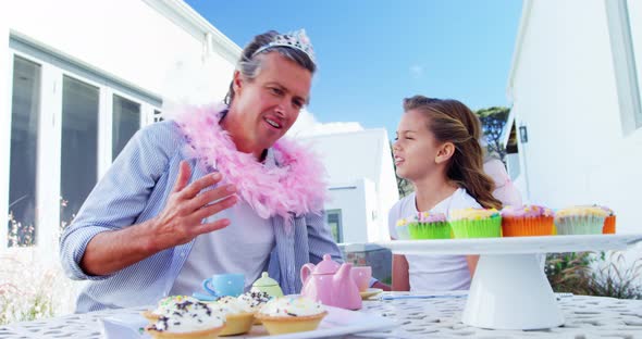 Smiling father and daughter in fairy costume having a tea party 4k alt