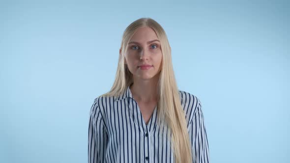 Blonde Young Woman Misunderstanding Something on Blue Background. alt