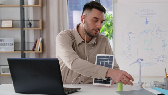 Male Teacher with Laptop and Solar Battery at Home