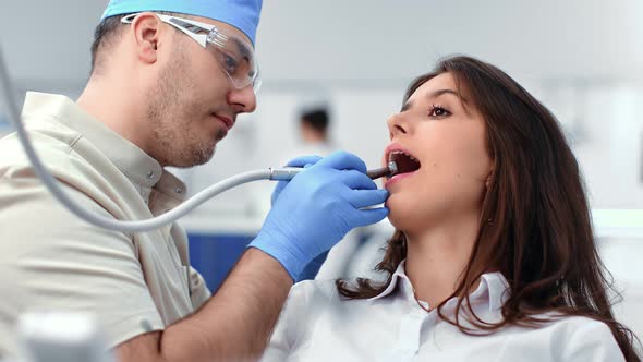 Woman Patient Sitting with Open Mouth Visited Doctor for Treatment Toothache Use Drilling Machine alt