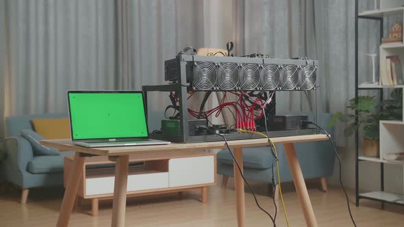 A Green Screen Laptop And Mining Rig On The Table For Mining Cryptocurrency alt