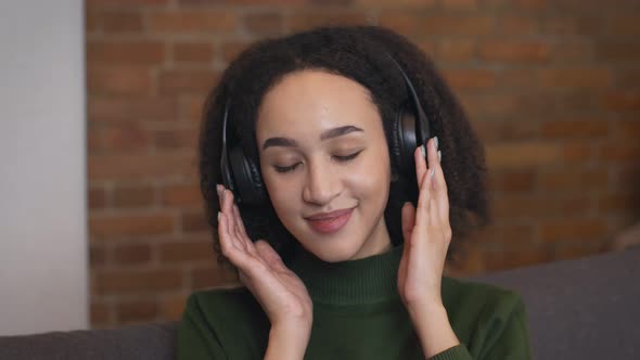Close Up Portrait of Relaxed African American Woman Enjoying Music in Wireless Headphones alt