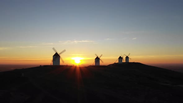 Aerial view of windmills in the countryside in Spain at sunrise alt