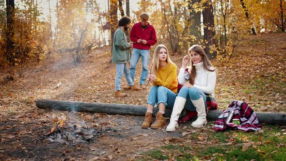 Young Friends Enjoying Picnic in Autumn Forest alt