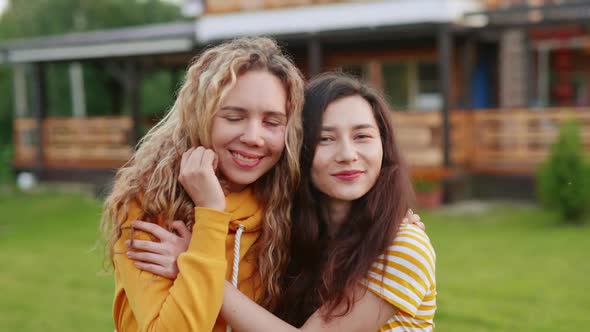 Portrait of Two Happy Women in Love. Asian Girl Kissing Her Girlfriend with a Scar on Her Face. Body alt