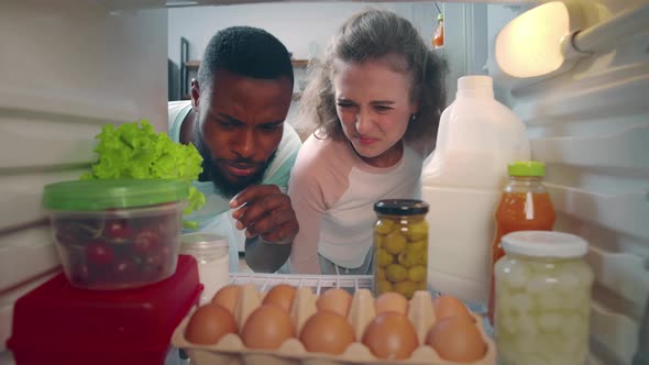 Multiracial Couple Open Fridge with Rotten Food alt