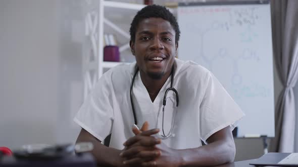 Confident Positive African American Doctor Talking in Video Chat Front View alt