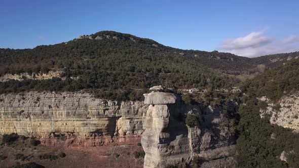Aerial view of vertical cliffs covered by green vegetation, arc shot alt