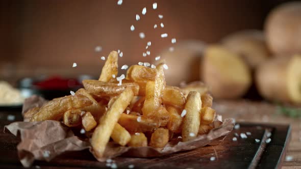 Super Slow Motion Shot of Adding Salt on Fresh French Fries at 1000Fps alt