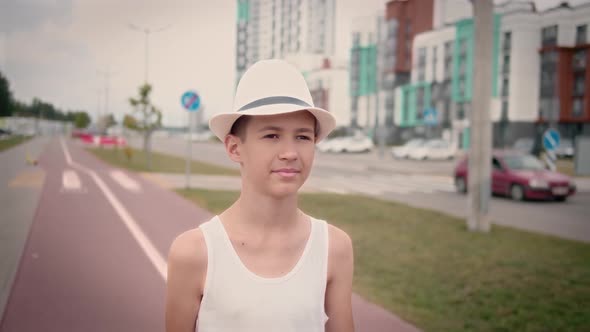 Funny Boy in a Hat Walking Down the Street in the Summer Cinematic Shot