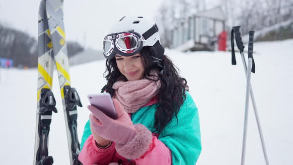 Young Caucasian Woman Surfing Internet on Smartphone Resting at Winter Resort alt