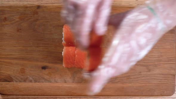Cooking Sushi at Home Closeup of Male Hands Placing Rolls on a Cutting Board alt