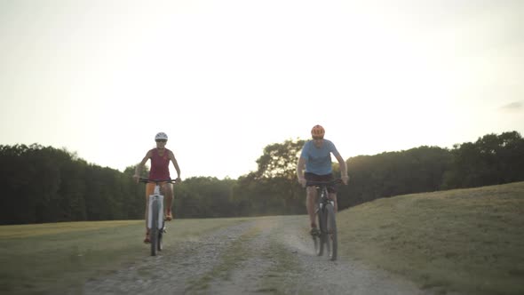 Couple Cycling in Grassland on Late Summer Afternoon
