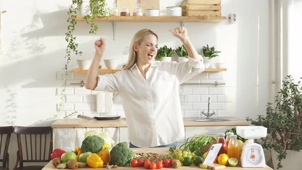 Blonde in Her Kitchen Put a Lot of Vegetables and Fruits on the Table She Dances at Home