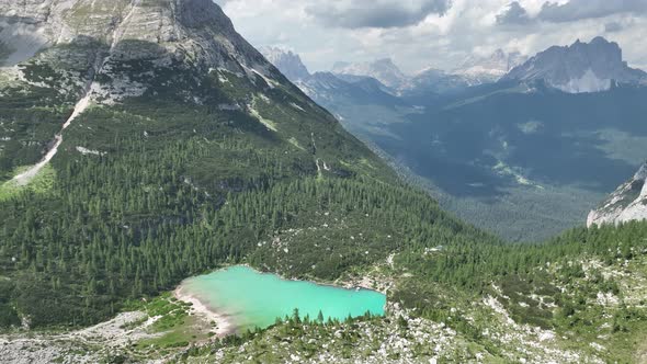 Hikers and travelers enjoying the turquoise Lago di Sorapiss (mountain lake) alt