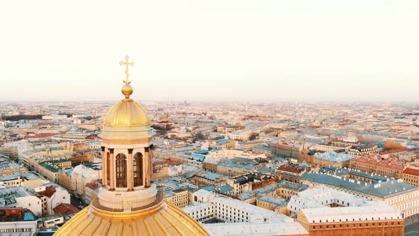 Aerial Flight Near the Golden Dome with a Cross of St. Isaac's Cathedral at Sunset alt