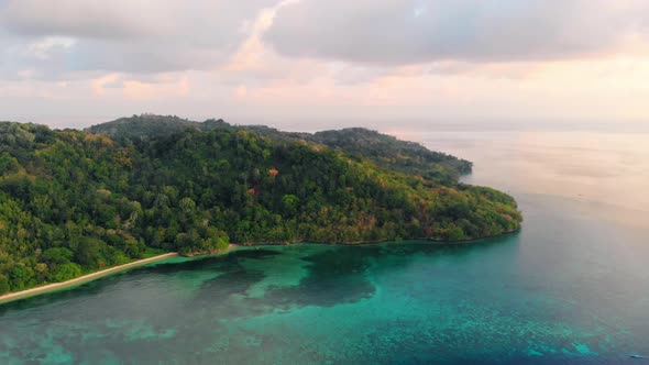Aerial: flying over tropical Hatta island white sand beach Banda Islands Maluku alt