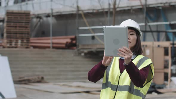 Construction supervisor taking picture with digital tablet of project development