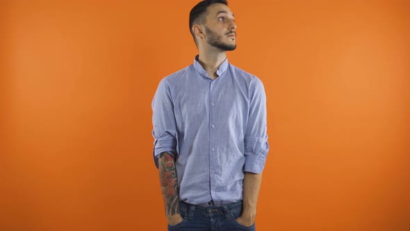 Sad, Desperate Young Man Looking Around Showing Empty Pockets. Concept of No Money. Poor Gesture alt