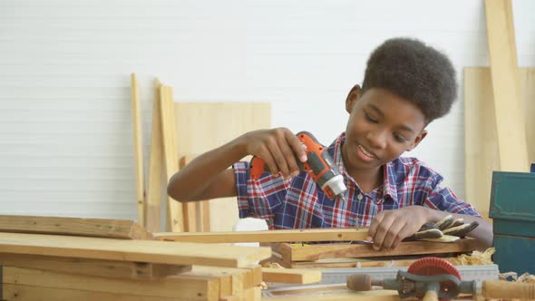 little child with a drill in hands help dad assembling furniture shelf with power screwdriver tool alt