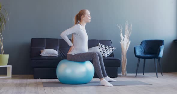 Pregnant Woman Exercising on Fitball at Home alt
