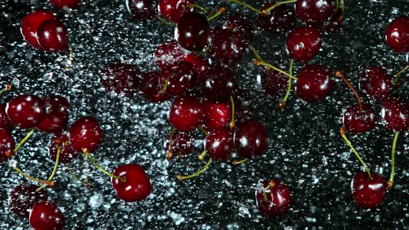 Super Slow Motion Shot of Flying Fresh Cherries and Water Side Splash  alt