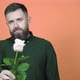 Handsome man holds out a rose to the camera - VideoHive Item for Sale