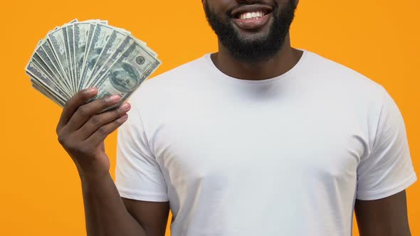 Joyful African Male Pointing Dollar Bills in Hand, Financial Success, Investment alt