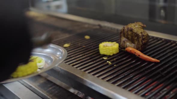 Professional Chef Cooking Vegetable on the Grill in the Restaurant Kitchen alt