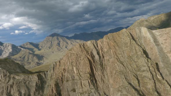 FPV Sports Drone Raising and Dive Fast Movement Nature Cliff Ridge Cracked Texture Mountain River alt