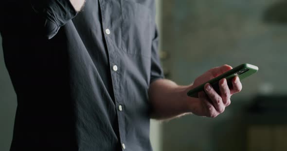 Man with a Glass of Beer and a Smartphone in His Hands