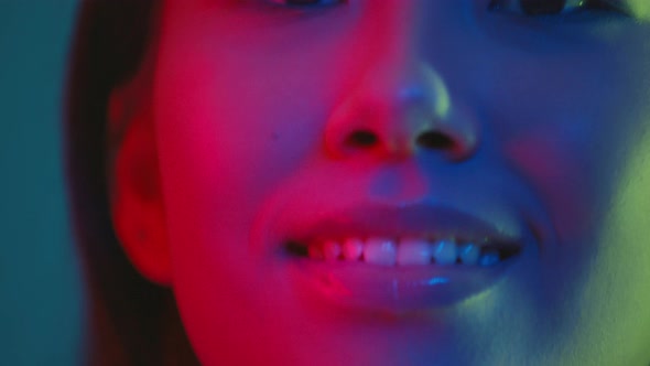 Close Up Portrait of Young Pretty Asian Woman Posing to Camera in Bright Colorful Neon Lights and alt