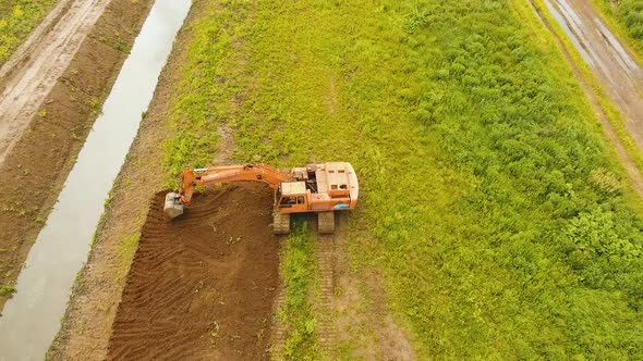 Excavator Digging a Trench in the Field alt