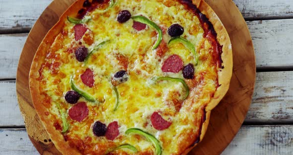 Baked pizza on wooden board alt