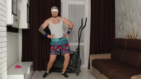 Funny Man Athlete Sportsman with Beard Makes Workout Stretching Exercises Practicing Sport at Home alt