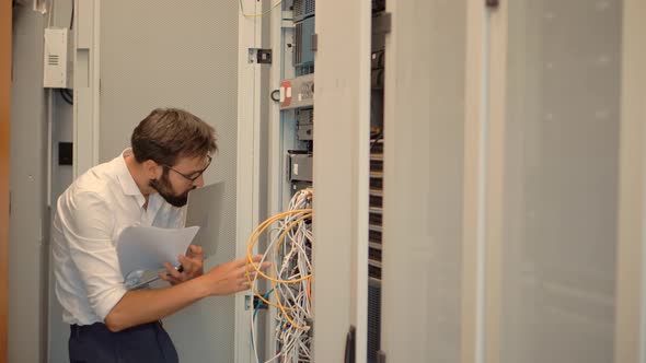 It Administrator Working In Server Room And Connecting Ethernet Wire.Web Network Hosting Server Room alt
