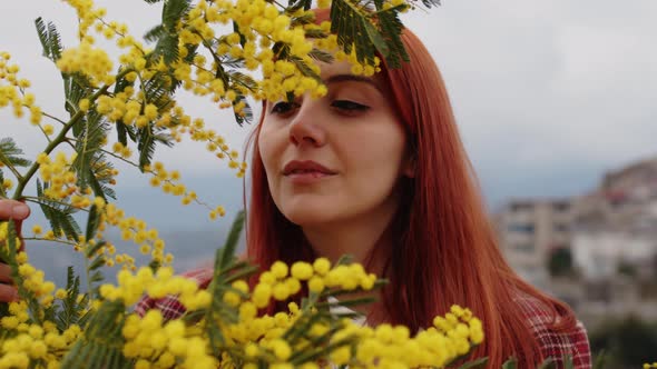 Young Girl Celebrates Women's Day with Yellow Mimosa Flowers in Hand alt