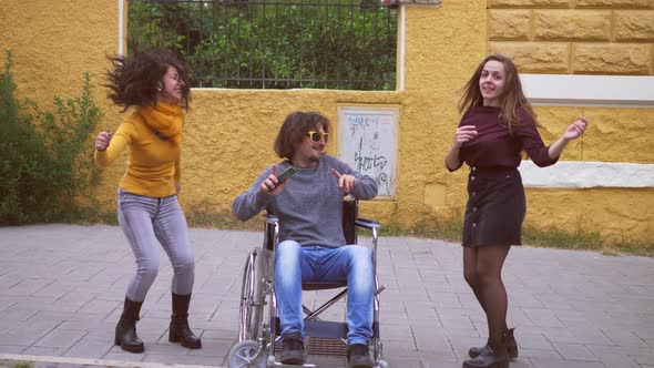 man using wheelchair dances with his friends - fun, disability alt