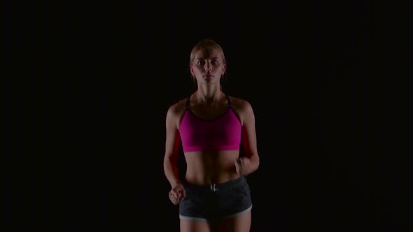 Woman Athlete Running Against on the Black Background. Slow Motion alt