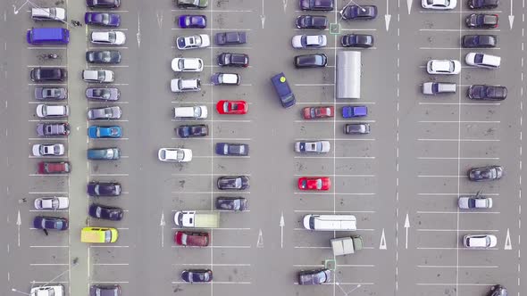 A bird's-eye view of parked cars in the parking lot near the shopping center. alt