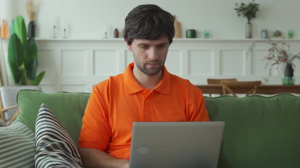 Happy Man Working at Computer at Home and Celebrating Victory with Raised Hands and Screaming alt