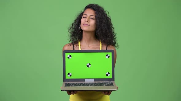 Young Beautiful Hispanic Woman Thinking While Showing Laptop alt